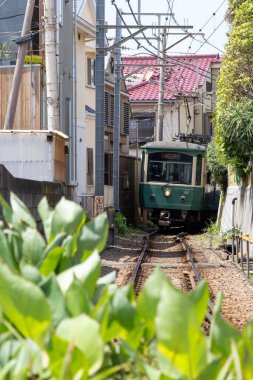 Kamakura, Japonya- 14 Mayıs 2024: Kamakura, Japonya 'daki Enoden treninin görüntüsü. Enoshima Elektrik Demiryolu, Kamakura 'dan Fujisawa' ya benzersiz ve manzaralı bir tren yolculuğu sunuyor.