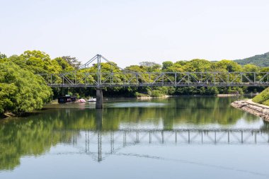 Okayama, Japonya - 10 Mayıs 2024: Okayama City, Japonya 'daki Asahi nehri üzerindeki Tsukimi köprüsü. Okayama 'daki Tsukimi-bashi köprüsü Okayama Kalesi ve Korakuen' i birbirine bağlıyor.