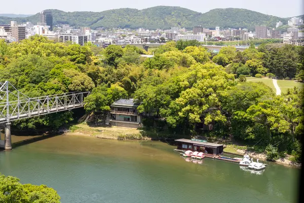 Okayama, Japonya - 10 Mayıs 2024: Okayama City, Japonya 'daki Asahi Nehri manzarası. Okayama Kalesi ve Korakuen bu nehrin tam karşısındaki yerdeler..