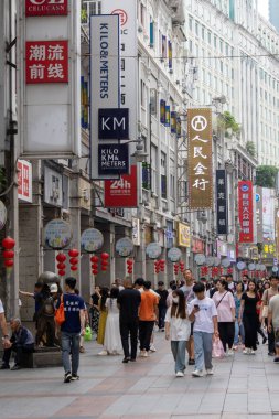 Guangzhou, Çin - 9 Haziran 2024: Çin 'in Guangzhou kentindeki ShangXiaJiu Pedestrian Caddesi' nde insanlar alışveriş yapıyor. Bu cadde yaklaşık 800 metre uzunluğunda ve her iki tarafında 250 dükkan var.