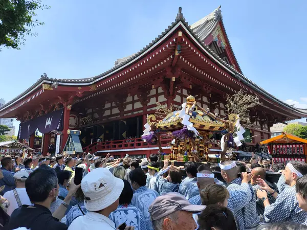 Tokyo, Japonya - 18 Mayıs 2024: Asakusa 'daki Sanja Festivali' nde taşınabilir bir türbe (mikoshi) taşıyan insanlar. Tokyo 'daki en popüler festivallerden biridir.