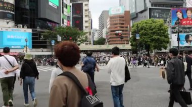 Tokyo, Japonya - 12 Mayıs 2024: İnsanlar Shibuya, Tokyo 'da işlek kavşağı geçiyor. Burası dünyanın en işlek kavşaklarından biri..