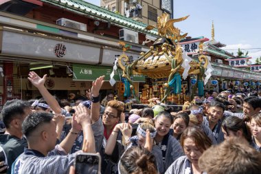 Tokyo, Japonya - 18 Mayıs 2024: Asakusa 'daki Sanja Festivali' nde taşınabilir bir türbe (mikoshi) taşıyan insanlar. Tokyo 'nun en popüler festivallerinden biridir..