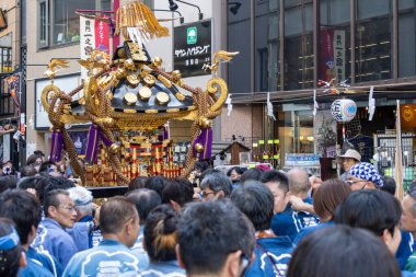 Tokyo, Japonya - 18 Mayıs 2024: Asakusa 'daki Sanja Festivali' nde taşınabilir bir türbe (mikoshi) taşıyan insanlar. Tokyo 'nun en popüler festivallerinden biridir..