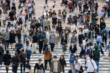 Tokyo, Japonya - 12 Mayıs 2024: İnsanlar Shibuya, Tokyo 'da işlek kavşağı geçiyor. Burası dünyanın en işlek kavşaklarından biri..