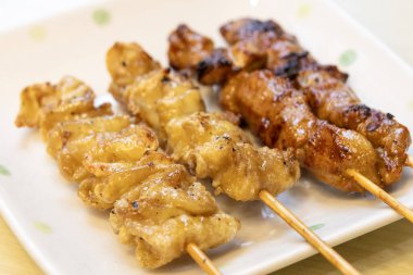 Japon yemeği yakitori, tavuk ve sığır eti, masada servis ediliyor.