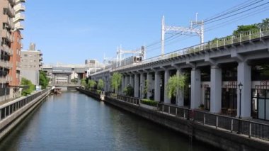 Tokyo, Japonya- 11 Mayıs 2024: Tokyo 'daki Kita Jyukken-gawa' dan yerel bir tren geçiyor.