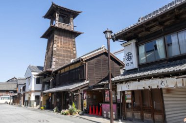 Kawagoe, Japonya- 17 Mayıs 2024: Japonya 'nın Saitama ilindeki Kawagoe şehri. Time 's Bell adında çan kulesi olan küçük bir caddenin manzarası.