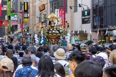 Tokyo, Japonya - 18 Mayıs 2024: Asakusa 'daki Sanja Festivali' nde taşınabilir bir türbe (mikoshi) taşıyan insanlar. Tokyo 'nun en popüler festivallerinden biridir..