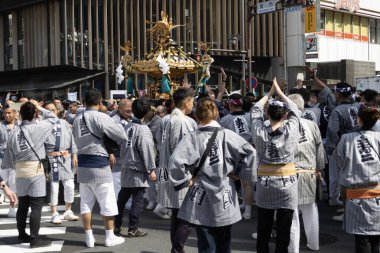 Tokyo, Japonya - 18 Mayıs 2024: Asakusa 'daki Sanja Festivali' nde taşınabilir bir türbe (mikoshi) taşıyan insanlar. Tokyo 'nun en popüler festivallerinden biridir..