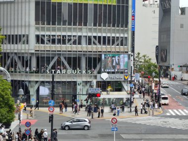 Tokyo, Japonya - 12 Mayıs 2024: Tokyo 'da Shibuya Scramble Crossing' in binalarda ticari reklam panosu ile görüntüsü. Tokyo 'da görülmeye değer bir manzara haline geldi.