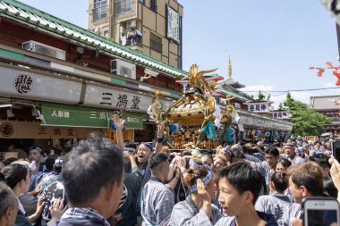 Tokyo, Japonya - 18 Mayıs 2024: Asakusa 'daki Sanja Festivali' nde taşınabilir bir türbe (mikoshi) taşıyan insanlar. Tokyo 'nun en popüler festivallerinden biridir..