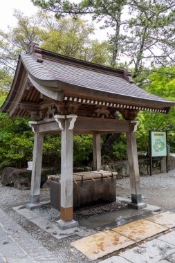 Kamakura, Japonya - 14 Mayıs 2024: Kamakura, Japonya 'daki Kotoku-in Tapınağı' ndaki kutsal kuyu.