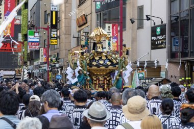 Tokyo, Japonya - 18 Mayıs 2024: Asakusa 'daki Sanja Festivali' nde taşınabilir bir türbe (mikoshi) taşıyan insanlar. Tokyo 'nun en popüler festivallerinden biridir..