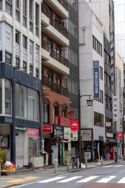 Tokyo, Japonya-12 Mayıs 2024: Tokyo 'nun ünlü Shibuya ilçesinde şehir sokak günü kış manzarası. Shibuya, Shibuya İstasyonu ve Shinjuku İstasyonu, dünyanın en işlek iki tren istasyonuna ev sahipliği yapar.