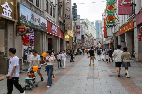 Guangzhou, Çin - 9 Haziran 2024: Çin 'in Guangzhou kentindeki ShangXiaJiu Pedestrian Caddesi' nde insanlar alışveriş yapıyor. Bu cadde yaklaşık 800 metre uzunluğunda ve her iki tarafında 250 dükkan var.