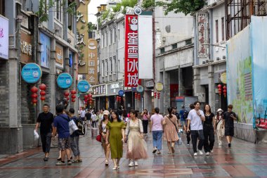 Guangzhou, Çin - 9 Haziran 2024: Çin 'in Guangzhou kentindeki ShangXiaJiu Pedestrian Caddesi' nde insanlar alışveriş yapıyor. Bu cadde yaklaşık 800 metre uzunluğunda ve her iki tarafında 250 dükkan var.