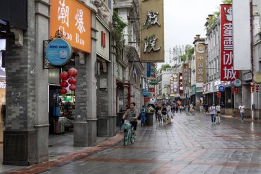 Guangzhou, Çin - 9 Haziran 2024: Çin 'in Guangzhou kentindeki ShangXiaJiu Pedestrian Caddesi' nde insanlar alışveriş yapıyor. Bu cadde yaklaşık 800 metre uzunluğunda ve her iki tarafında 250 dükkan var.