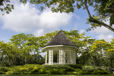 Singapur Botanik Bahçeleri 'nde çardak veya beyaz orkestra sehpası. Orkestra standı 1930 'da kuruldu ve orijinal şeklini korudu.