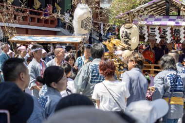Tokyo, Japonya - 18 Mayıs 2024: Asakusa 'daki Sanja Festivali' nde taşınabilir bir türbe (mikoshi) taşıyan insanlar. Tokyo 'nun en popüler festivallerinden biridir..