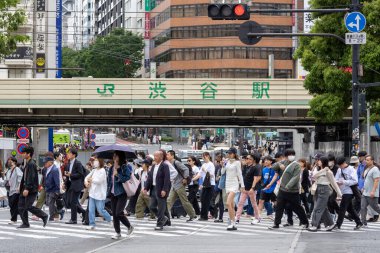 Tokyo, Japonya - 12 Mayıs 2024: İnsanlar Shibuya, Tokyo 'da işlek kavşağı geçiyor. Burası dünyanın en işlek kavşaklarından biri..