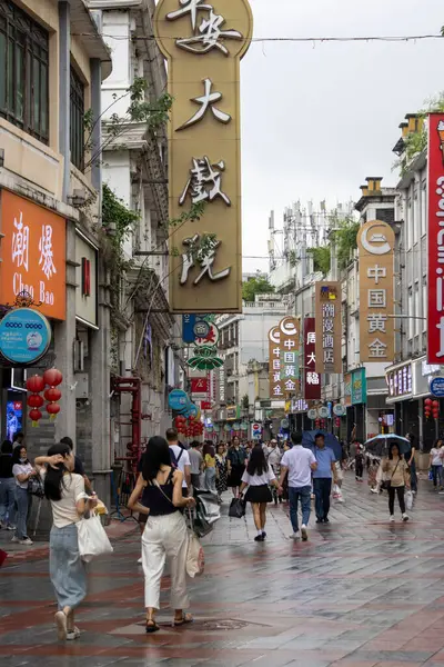 Guangzhou, Çin - 9 Haziran 2024: Çin 'in Guangzhou kentindeki ShangXiaJiu Pedestrian Caddesi' nde insanlar alışveriş yapıyor. Bu cadde yaklaşık 800 metre uzunluğunda ve her iki tarafında 250 dükkan var.