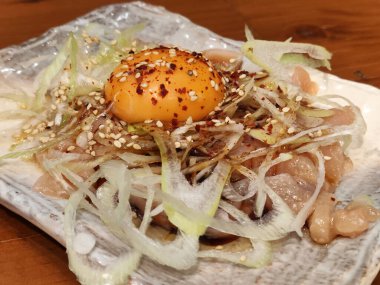 Yukhoe usulü çiğ yumurta ve soğanlı tavuk, Kore usulü doğranmış çiğ ettir.