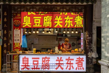 Guangzhou, Çin-7 Haziran 2014: Çin 'in Guangzhou kentindeki Shang Xia Jiu yürüyüş sokağında sokak yemekleri satıcısı