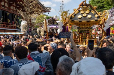 Tokyo, Japonya - 18 Mayıs 2024: Asakusa 'daki Sanja Festivali' nde taşınabilir bir türbe (mikoshi) taşıyan insanlar. Tokyo 'nun en popüler festivallerinden biridir..