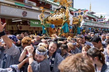 Tokyo, Japonya - 18 Mayıs 2024: Asakusa 'daki Sanja Festivali' nde taşınabilir bir türbe (mikoshi) taşıyan insanlar. Tokyo 'nun en popüler festivallerinden biridir..