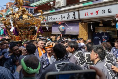 Tokyo, Japonya - 18 Mayıs 2024: Asakusa 'daki Sanja Festivali' nde taşınabilir bir türbe (mikoshi) taşıyan insanlar. Tokyo 'nun en popüler festivallerinden biridir..