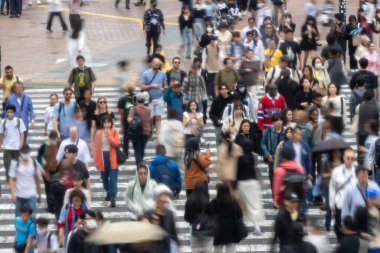 Tokyo, Japonya - 12 Mayıs 2024: İnsanlar Shibuya, Tokyo 'da işlek kavşağı geçiyor. Burası dünyanın en işlek kavşaklarından biri. (kasıtlı olarak insanların hareketlerini göstermek için bulanık)