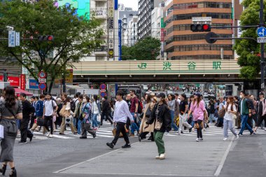 Tokyo, Japonya - 12 Mayıs 2024: İnsanlar Shibuya, Tokyo 'da işlek kavşağı geçiyor. Burası dünyanın en işlek kavşaklarından biri..