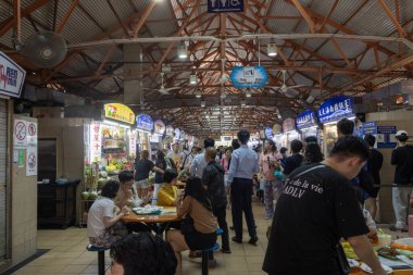 Singapur - 4 Ekim 2024: Yerel halk ve turist öğle yemeği saatlerinde otantik Maxwell gıda merkezinde yemeklerini yiyorlar. 