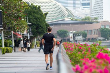 Singapur - 4 Ekim 2024: Turistler Singapur 'daki Marina Körfezi boyunca yürüyorlar. Marina Körfezi yakınlarında bir sürü eğlence yeri var..