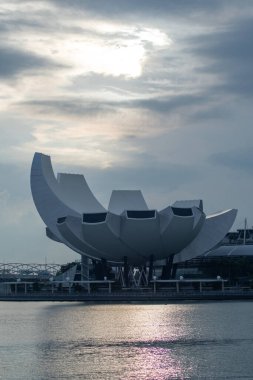 Singapur - 4 Ekim 2024 Merlion Park 'tan görüldüğü gibi Singapur Sanat Müzesi ile güzel bir gün doğumu. Mimarinin nilüfer çiçeğini andırdığı söylenir..