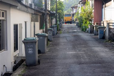 Johor Bahru, Malezya - 29 Sep 2024: Johor Bahru, Malezya 'da çöp tenekesi bulunan mahalle evinin arka sokağı