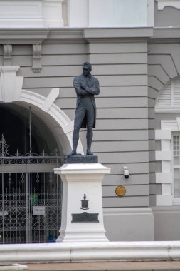 Singapur - 4 Ekim 2024 Singapur 'un kurucusu Stamford Raffles' ın heykeli Victoria Tiyatrosu ve Konser Salonu önünde duruyor. Tarihi bina 1862 yılına dayanıyor..