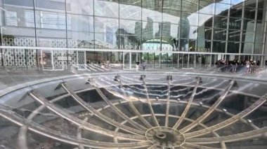 Singapur, 19 Ekim 2024: MBS 'de Yağmurlu Oculus ile Ayakkabılar Girişi, Singapur Yağmur Oculus, 70 metre çapında bir akrilik kase içinde büyük bir girdap şeklidir ve 2 kat aşağıdaki bir havuza düşer.