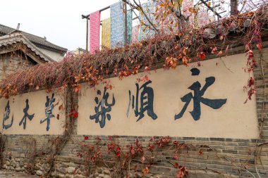 Pekin, Çin-11 Kasım 2024: Yongshun Dye House Gubei Su Kasabası, Pekin. Burası, farklı renkte kumaşlar etrafta dolaşırken fotoğraf çekmek için iyi bir yer.