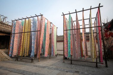 Beijing, China- 8 Nov 2024:  Yongshun Dye House located in Gubei Water Town, Beijing. This is a good spot to take pictures with the different colors of the cloths hanging around clipart