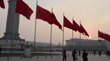 Pekin, Çin - 1 Kasım 2024: Pekin 'de gün batımında Tiananmen Meydanı' nda kırmızı bayraklar.