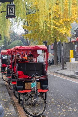 Beijing, China-11 Nov 2024: Traditional rickshaws wait for customers at Shichahai in Beijing.  It is the ideal way to see local Beijing clipart