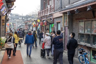 Pekin, Çin-11 Kasım 2024: İnsanlar Pekin 'deki Yandaixie caddesini ziyaret ediyor. Yandaixie Caddesi, Pekin 'de geleneksel avlu evleri arasında kurulan bir kulübe kompleksi.