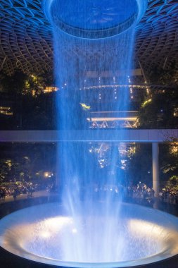 Singapur - 31 Ekim 2024: Aydınlanmış adam Singapur 'daki Jewel Changi' de şelale yaptı. Jewel Changi, Changi Havaalanı Terminali 'ne doğrudan bağlı bir alışveriş merkezidir.