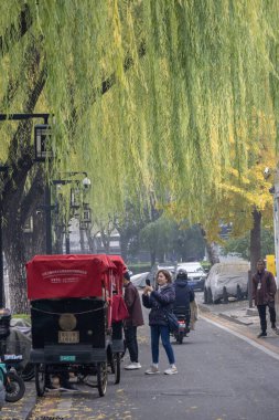 Pekin, Çin-11 Kasım 2024: Geleneksel triportörler Pekin 'deki Shichahai' de müşterileri bekliyor. Yerel Pekin 'i görmek için ideal bir yol.