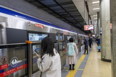 Pekin, Çin - 1 Kasım 2024: Yolcular Pekin, Çin 'deki metro istasyonunda treni bekliyorlar. Pekin 'de seyahat etmenin en kolay yoludur..