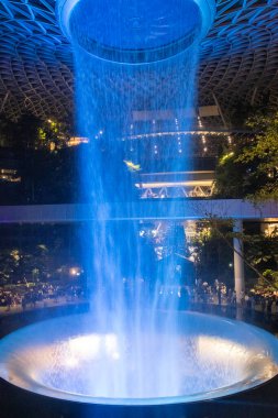 Singapur - 31 Ekim 2024: Aydınlanmış adam Singapur 'daki Jewel Changi' de şelale yaptı. Jewel Changi, Changi Havaalanı Terminali 'ne doğrudan bağlı bir alışveriş merkezidir.