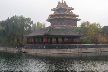 Beijing, China- 2 Nov 2024: Forbidden City Corner Tower, or Jiaolou tower and river in the misty day. It is a landmark in Beijing, China clipart