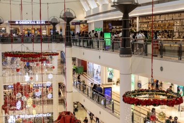 Kuala Lumpur, Malezya - 23 Aralık 2024: İnsanlar Suria KLCC alışveriş merkezini ziyaret ediyor. Alışveriş merkezi, ünlü Petronas Kuleleri yakınlarındaki Kuala Lumpur şehir merkezinde yer almaktadır..